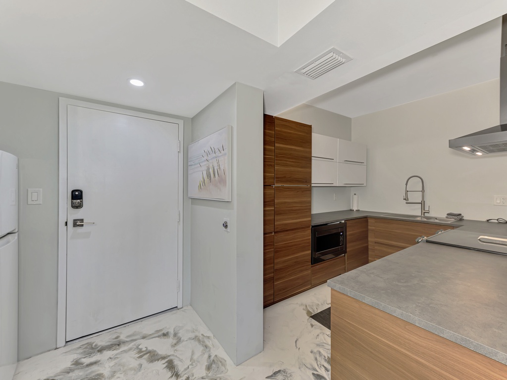 Your sleek kitchen features wood-grain cabinets and stone countertops, perfect for preparing meals in style.