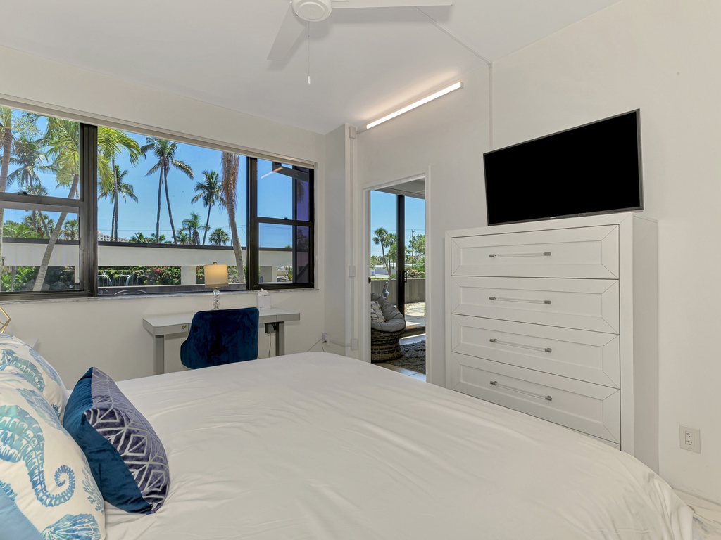 Wake up to tropical palm tree views from your comfortable bed, with modern amenities and terrace access for the perfect morning retreat.