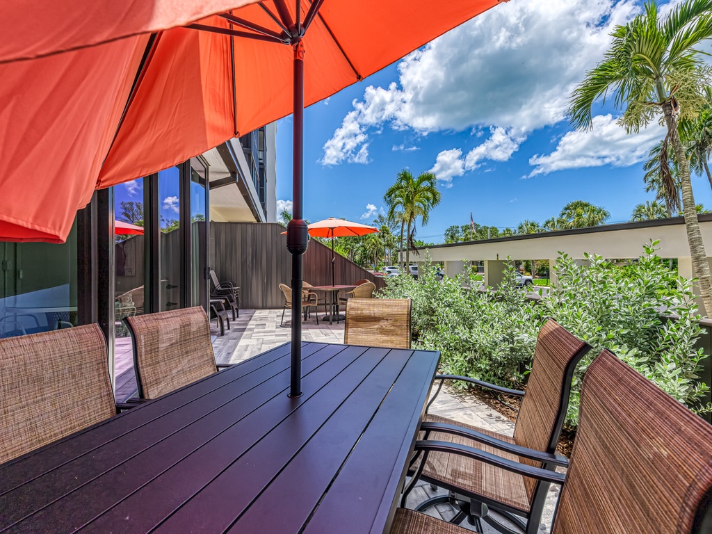Unwind on your private deck with tropical garden views and comfortable wicker seating under bright orange umbrellas.
