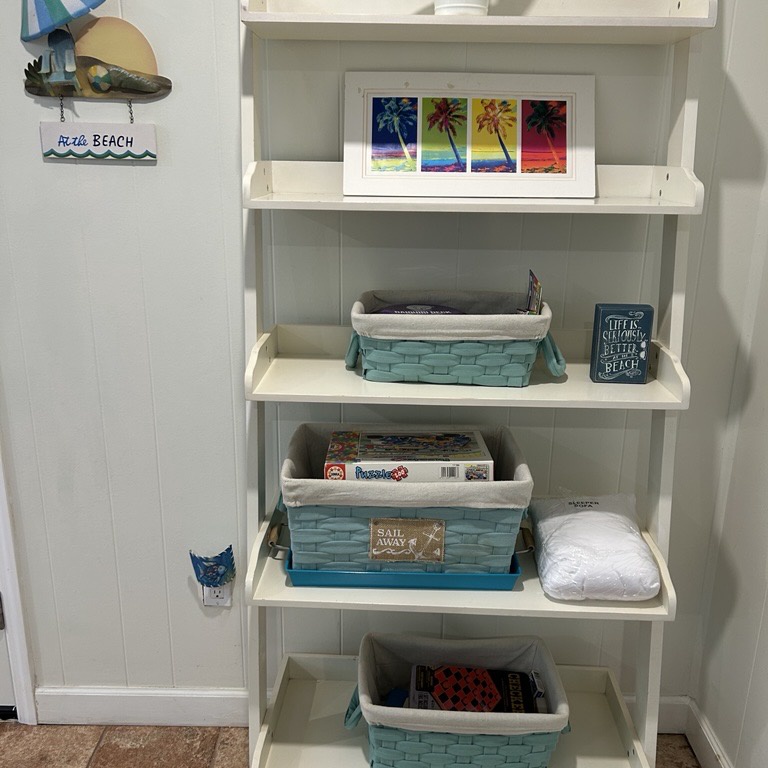 Your coastal-themed shelving unit holds beach games, books, and towels - everything you need for perfect seaside getaways right at your fingertips.