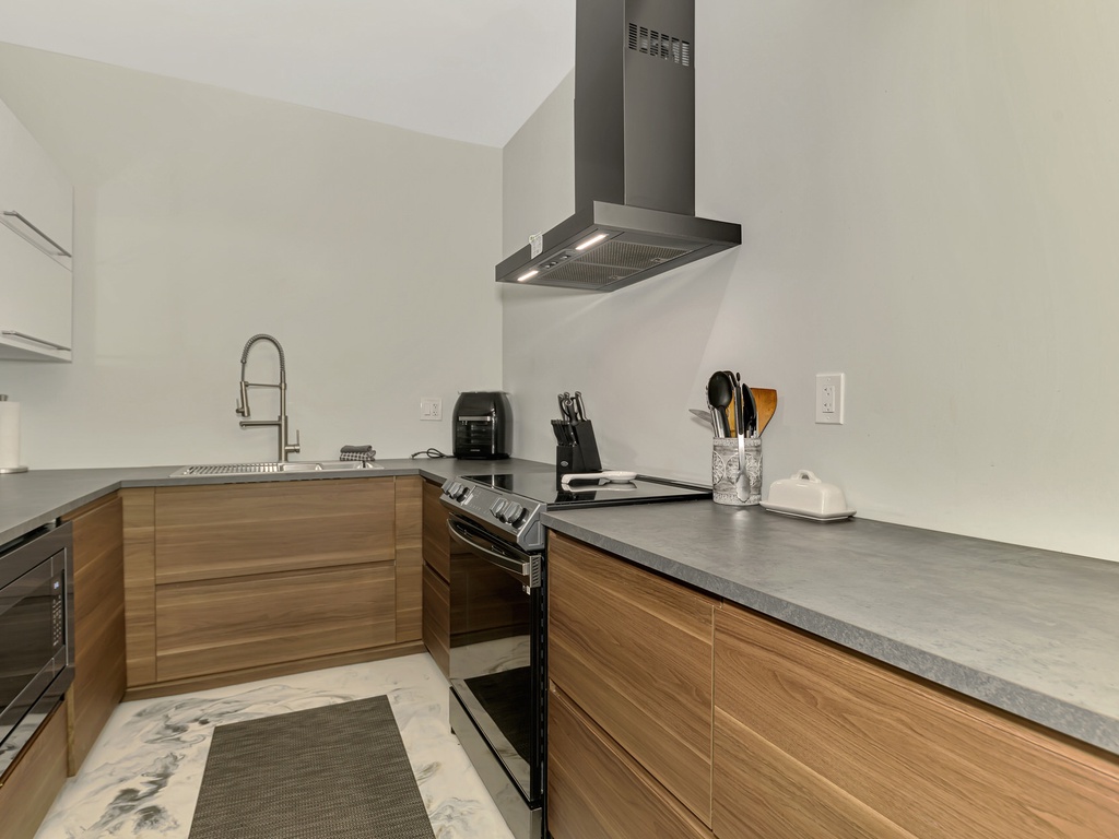 Your modern kitchen features sleek wood cabinets, stainless steel appliances, and ample counter space for cooking memorable meals.