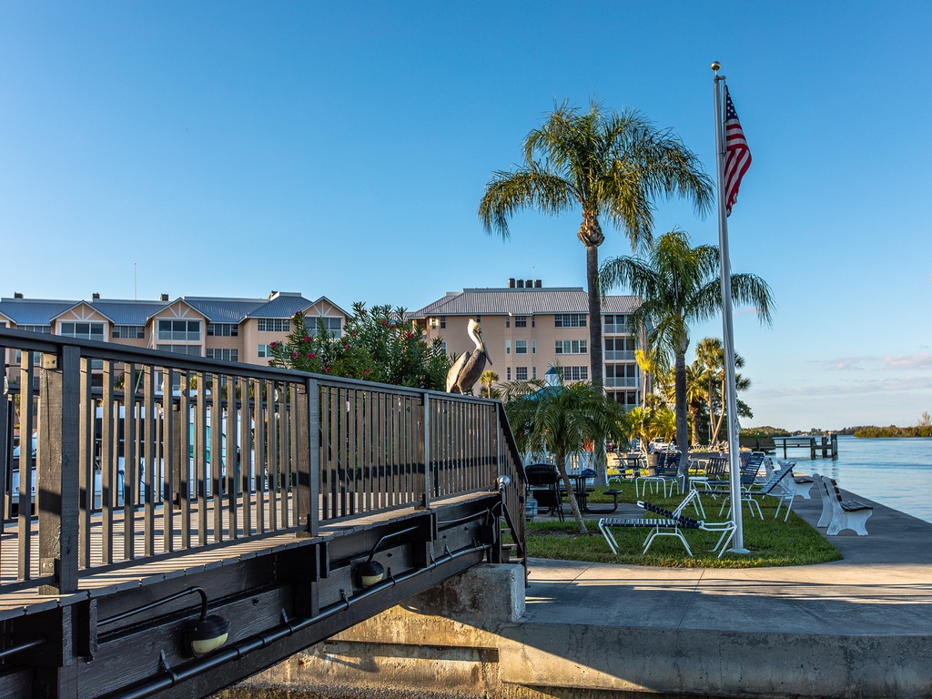 Waterfront property featuring private dock, palm trees, and peaceful bay views in a scenic coastal setting.