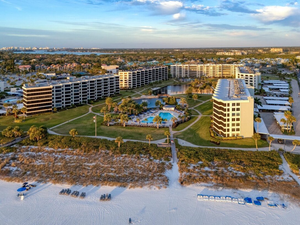 Beachfront resort complex with multiple buildings, pool facilities, and direct beach access on pristine white sand coastline.