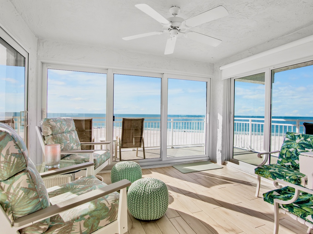 Your bright oceanfront living room opens to endless sea views through floor-to-ceiling windows, creating the perfect coastal retreat.