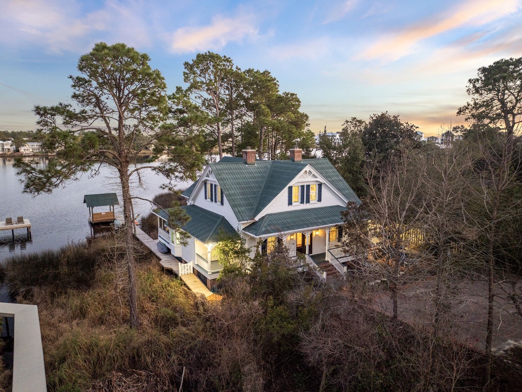 Charming lakefront home with private dock nestled among mature trees, offering peaceful waterfront views in a serene neighborhood setting.