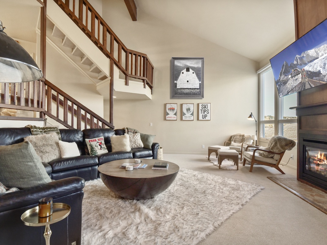 Sink into plush leather seating by your crackling fireplace, where mountain views and cozy textures create your perfect retreat.