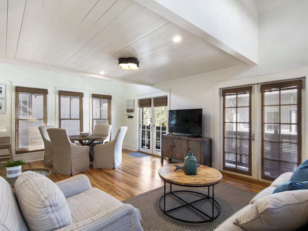 Settle into your bright, airy living space with soaring shiplap ceilings and warm wood floors. Natural light fills the room through French doors opening to your private deck, perfect for morning coffee or evening relaxation.