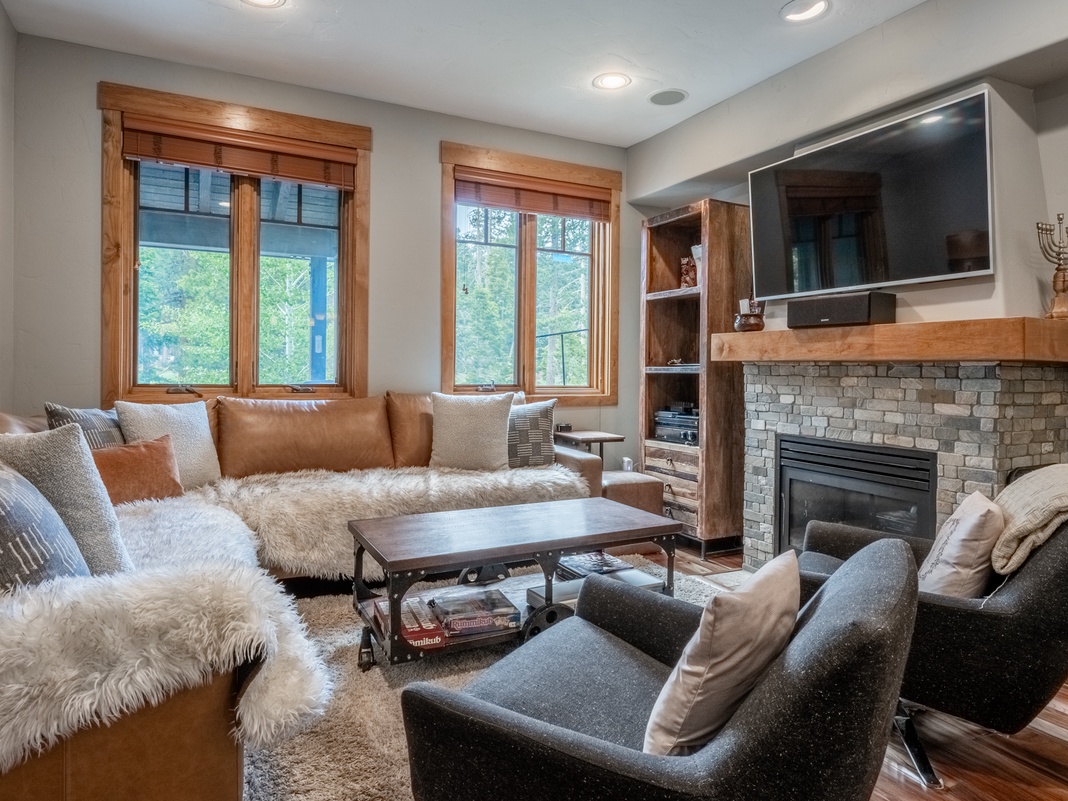 Sink into plush textures and rustic warmth as you unwind by the fireplace, surrounded by natural light and cozy seating designed for your complete relaxation.