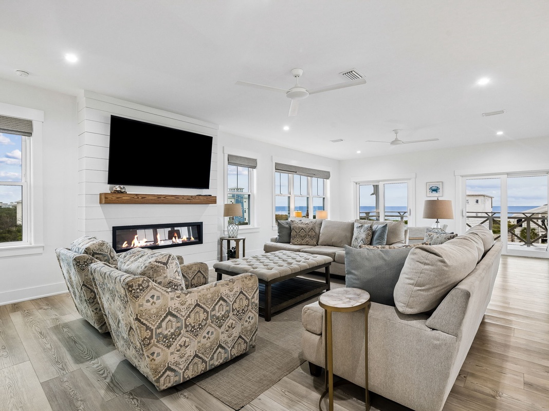 Sink into plush seating and watch ocean waves through expansive windows. The coastal ambiance and cozy fireplace create your perfect retreat after sunny beach days.