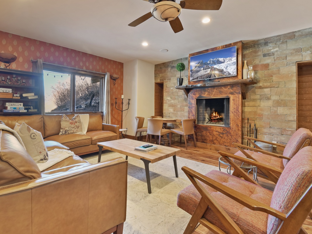 Cozy up by the crackling fireplace in your spacious living area, where leather seating and mountain views create the perfect retreat.