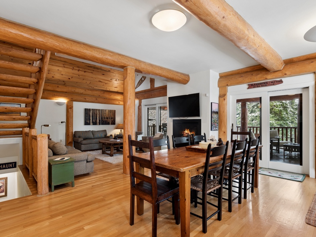 Gather around your rustic dining table while warm wood beams frame cozy evenings by the fireplace.