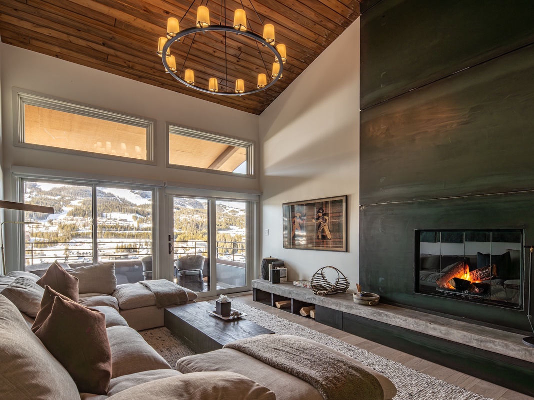 Sink into plush cushions by your crackling fireplace, where mountain views create the perfect backdrop for cozy evenings.
