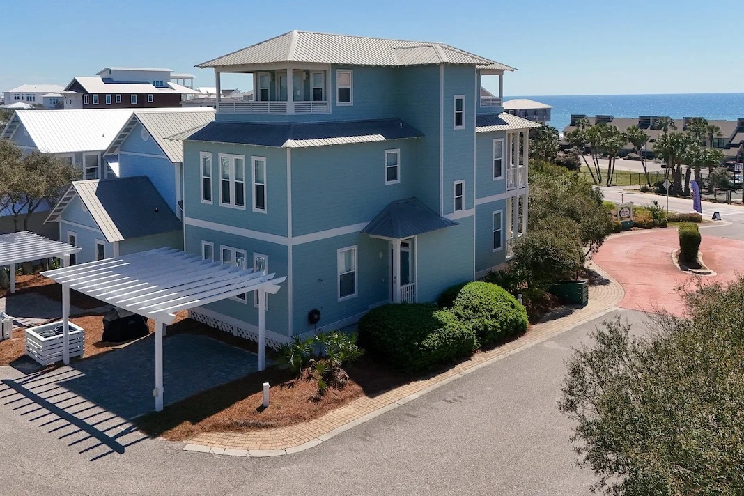 This coastal vacation home features three stories of beachside living with modern architecture and a spacious rooftop observation deck. The property sits within a serene residential neighborhood offering close proximity to the shore.