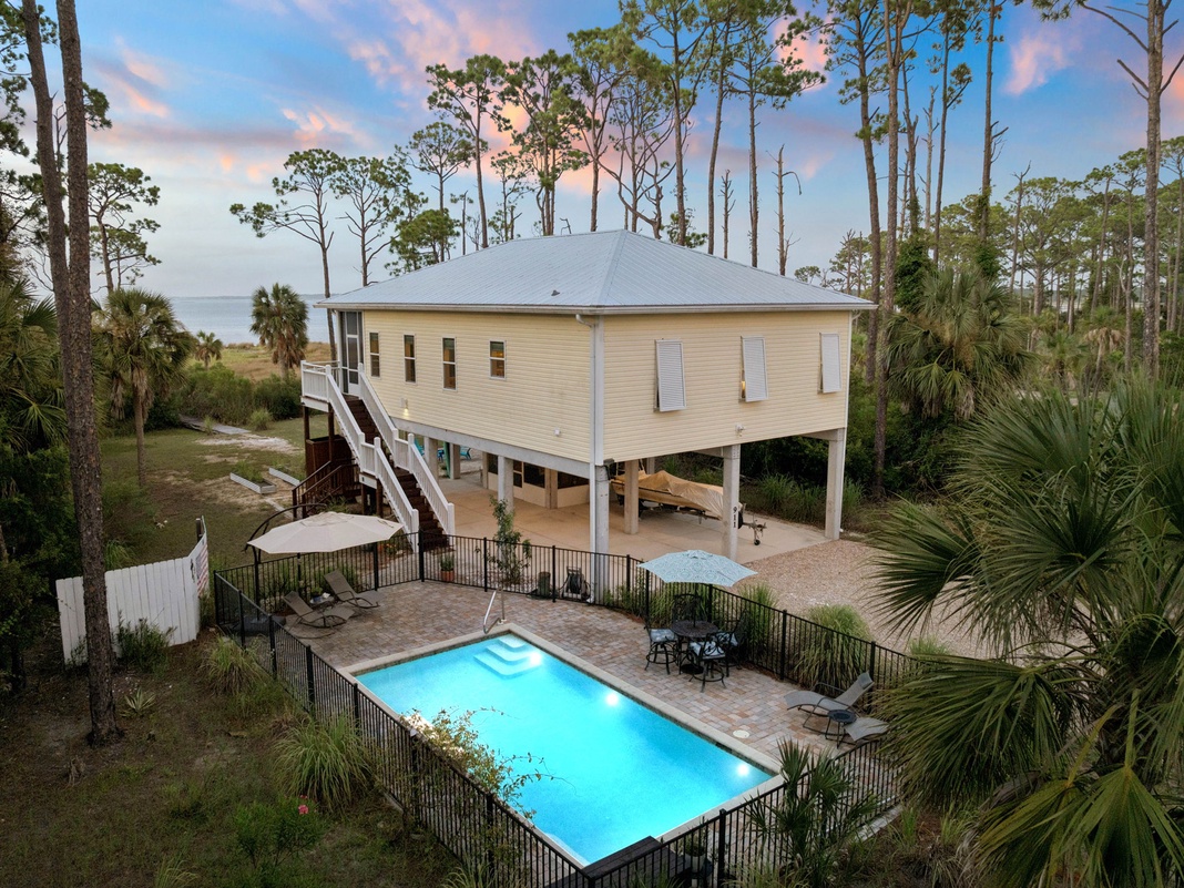 Elevated coastal retreat nestled among towering pines with private pool, waterfront access, and peaceful natural surroundings perfect for your escape.