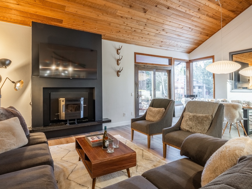 Sink into plush seating by your crackling fireplace, surrounded by warm wood beams and modern mountain elegance.