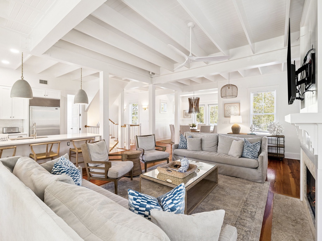 Gather with loved ones in this stunning open-concept living space featuring soaring vaulted ceilings and elegant coastal design.