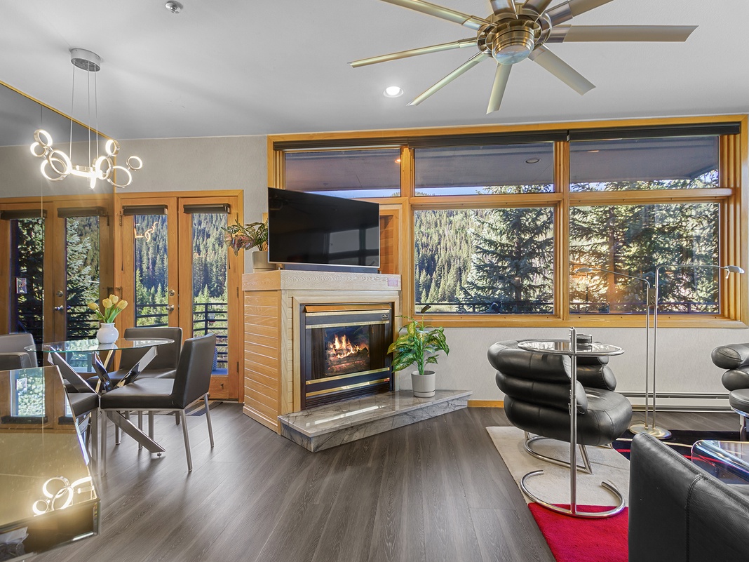 Settle into your bright, modern living space where floor-to-ceiling windows frame stunning forest and mountain scenery. Gather by the cozy fireplace or step out onto your private deck to soak in the alpine views.