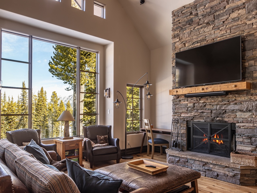 Sink into cozy leather seating by your crackling fireplace while taking in stunning mountain views through floor-to-ceiling windows.