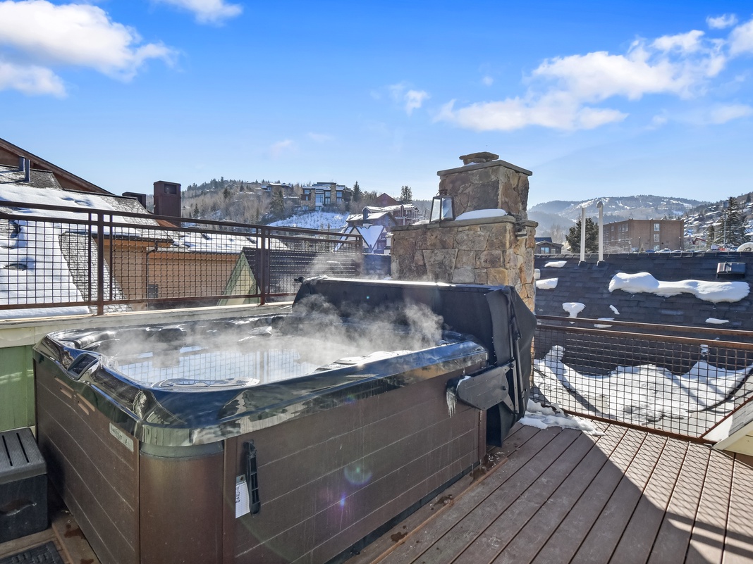 Soak in your private hot tub while winter snow blankets the mountain town around you, creating the perfect alpine getaway.