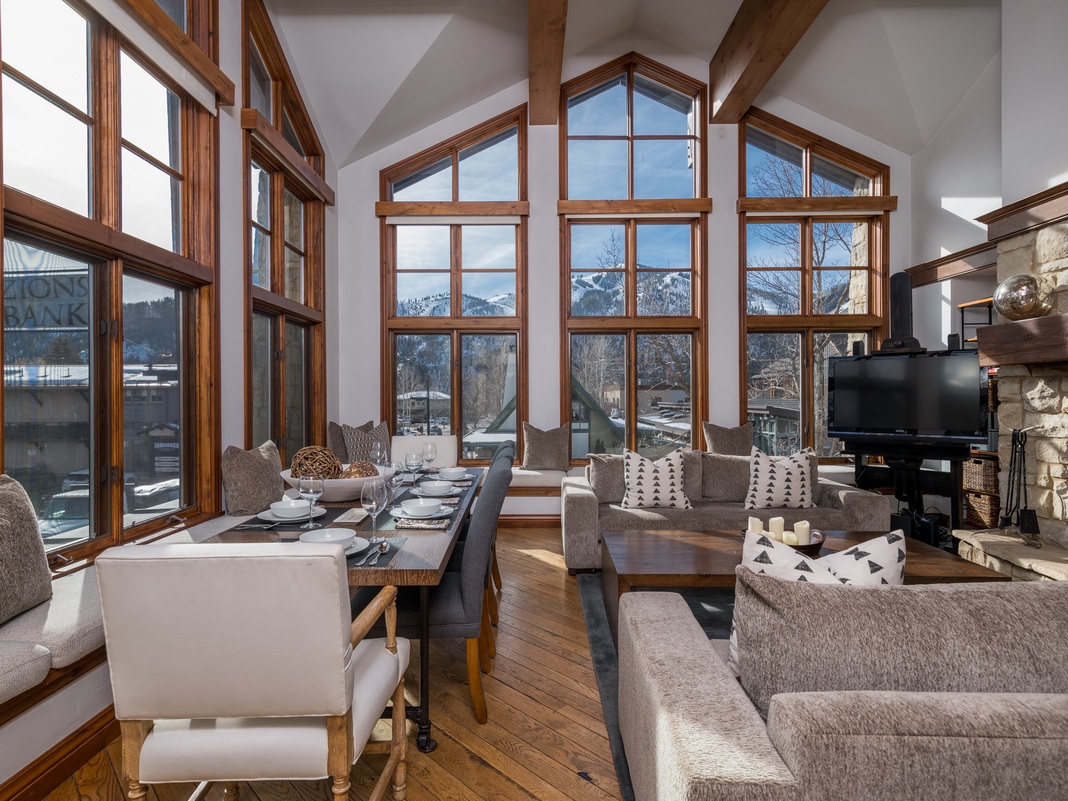 Stunning mountain views frame your spacious open-plan living area, where floor-to-ceiling windows flood the room with natural light.