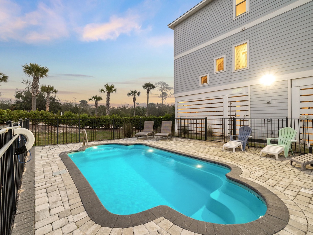 Your private oasis awaits with a sparkling pool surrounded by tropical palms and comfortable lounging areas for ultimate relaxation.