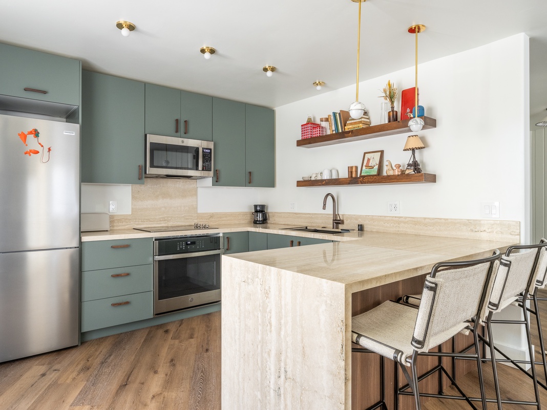 Your stylish kitchen features sage cabinetry, stainless appliances, and a marble island perfect for morning coffee or meal prep.