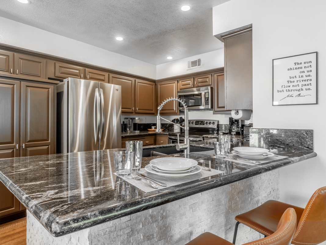 Your gourmet kitchen invites you to create memorable meals with gleaming granite countertops, stainless steel appliances, and a breakfast bar perfect for morning coffee or casual dining.