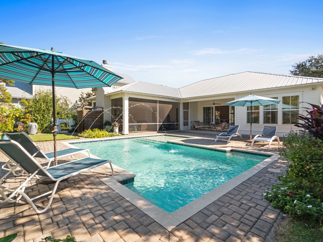 Stunning vacation home featuring a sparkling private pool surrounded by tropical landscaping under bright Florida skies.