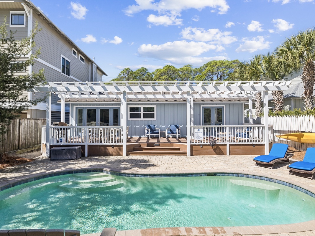Dive into your private oasis with a sparkling pool and spacious deck perfect for lounging under the pergola.
