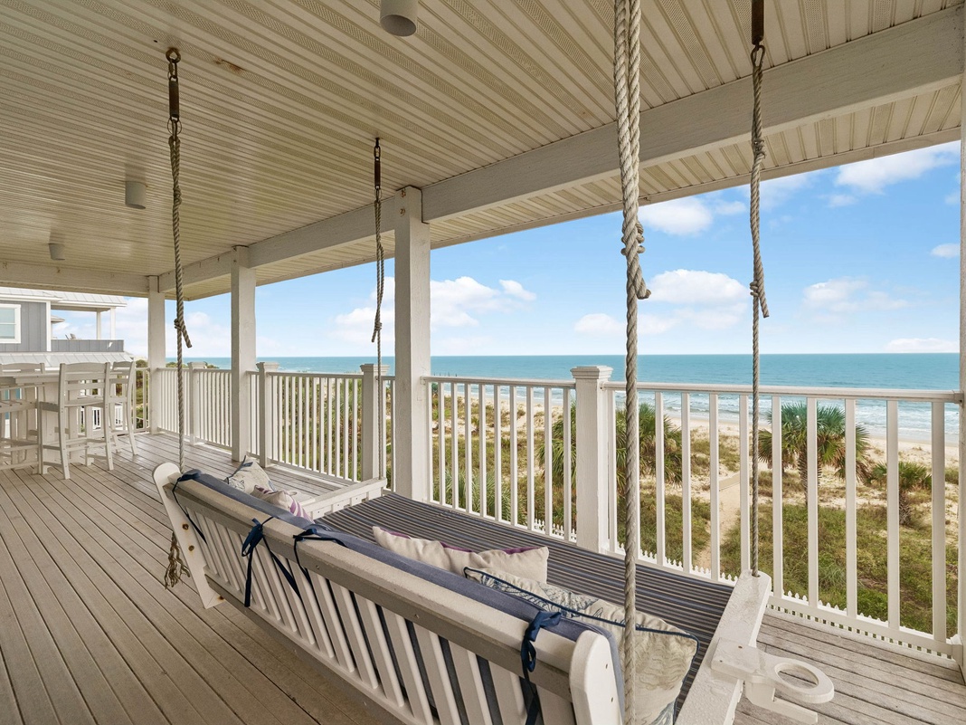Settle into the gentle sway of your private porch swing and let the sound of the ocean waves wash over you, framing your perfect beachfront escape.