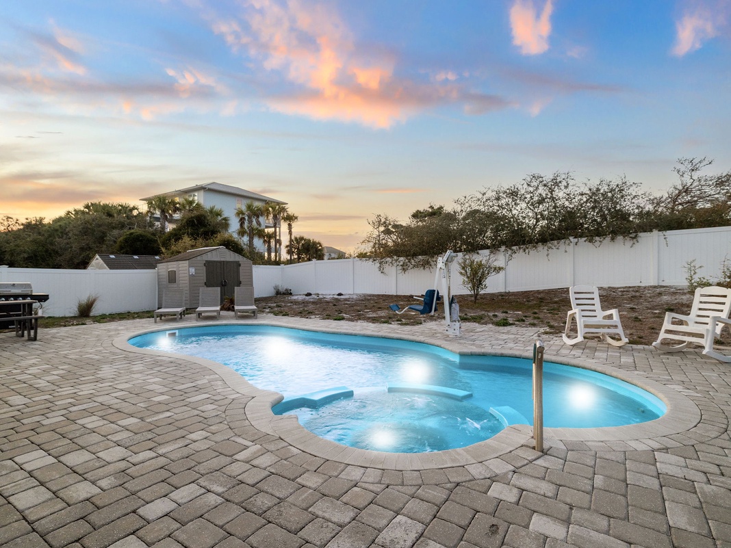 Your private pool glows under painted sunset skies, surrounded by comfortable loungers for evening relaxation.