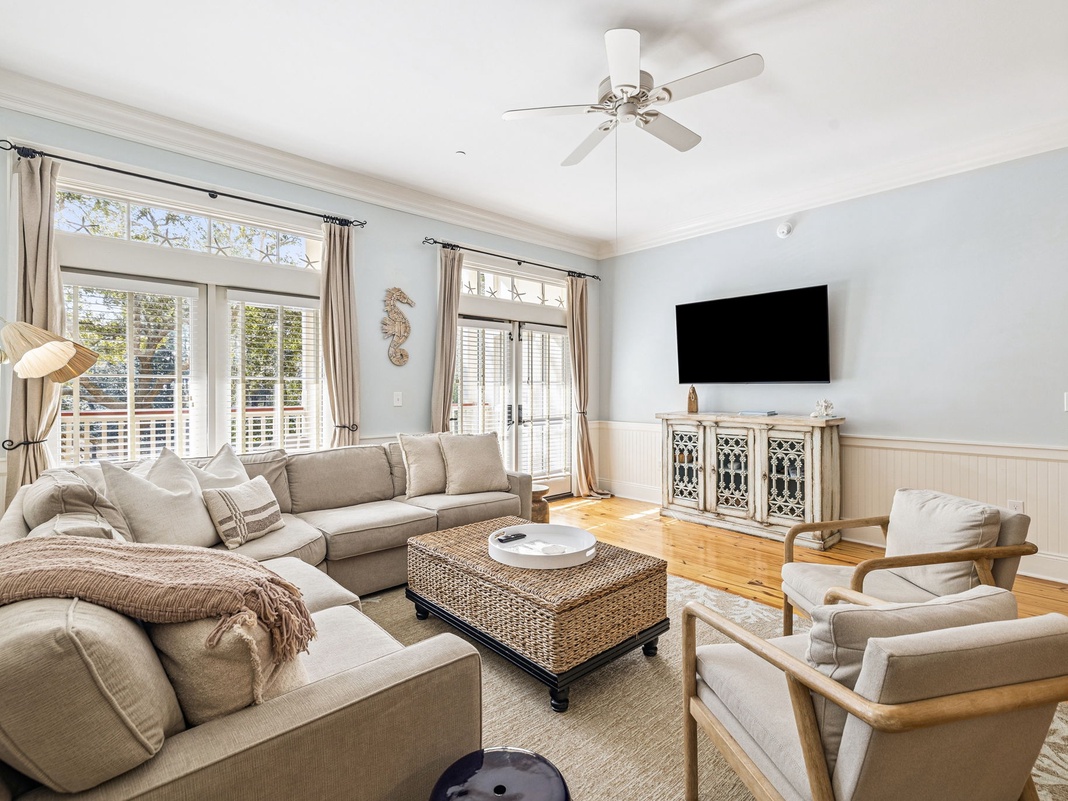 Sink into plush sofas in your bright living room, where natural light streams through French doors and a ceiling fan keeps you comfortable.