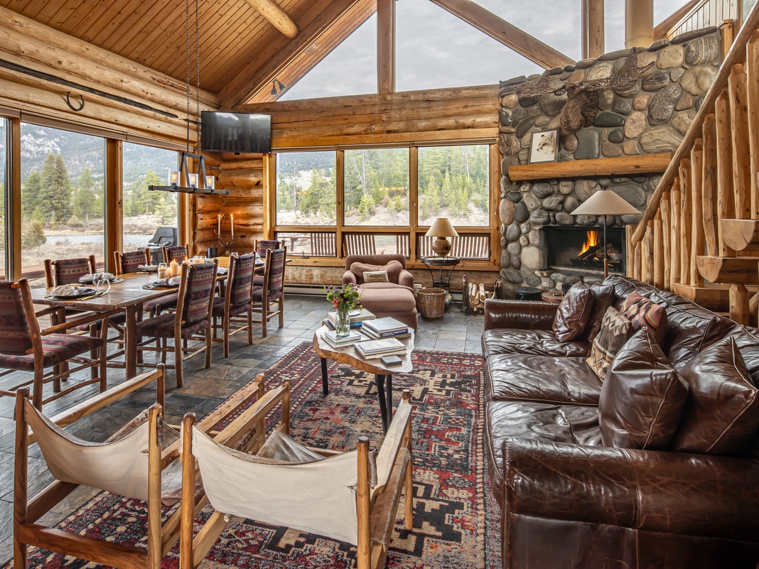 Sink into rich leather sofas by the crackling stone fireplace, where mountain views through floor-to-ceiling windows create your perfect retreat.