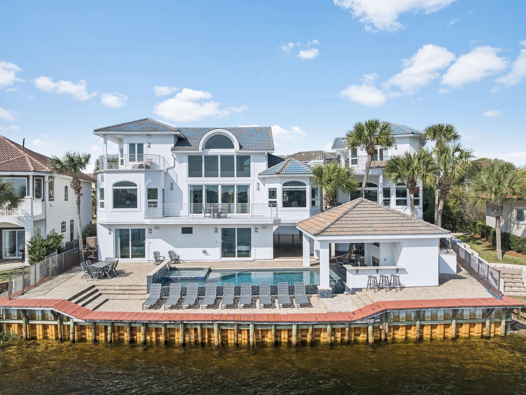 Stunning waterfront estate with private pool, outdoor entertaining area, and direct water access in a prestigious coastal neighborhood.