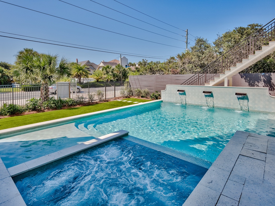 Dive into your private oasis with sparkling pool, bubbling spa, and elegant water features surrounded by lush tropical landscaping.