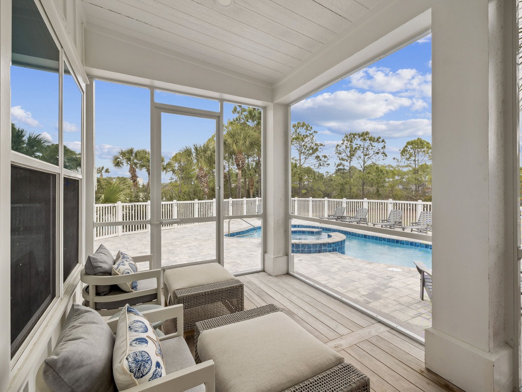 Relax in your screened porch with pool views, where comfortable seating and tropical breezes create the perfect retreat.