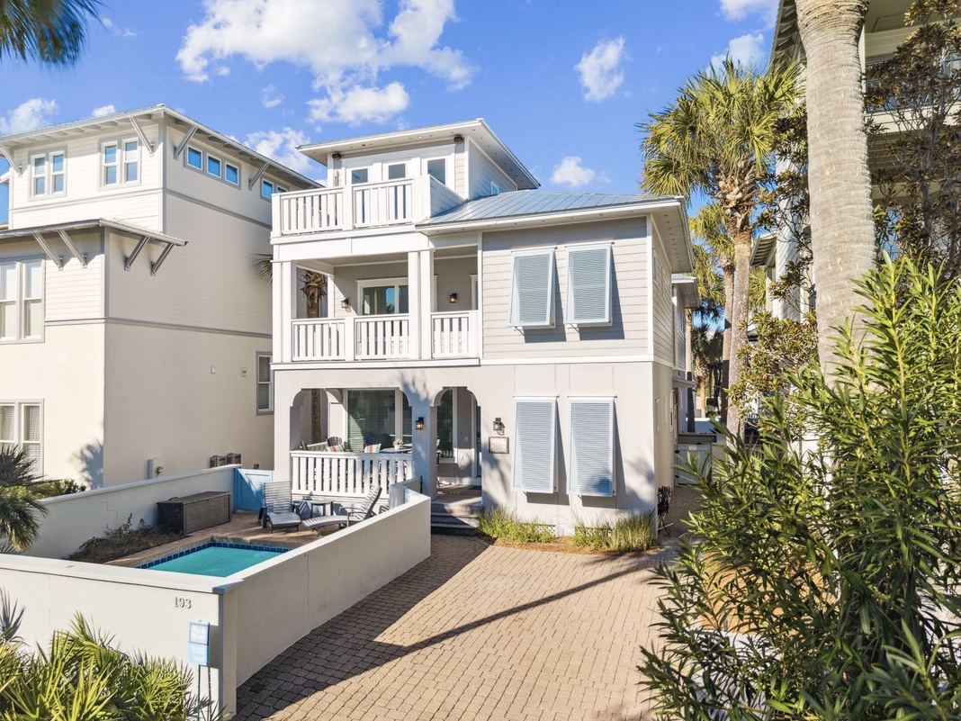 Stunning coastal cottage with private pool surrounded by swaying palms and tropical landscaping in this peaceful beachside neighborhood.
