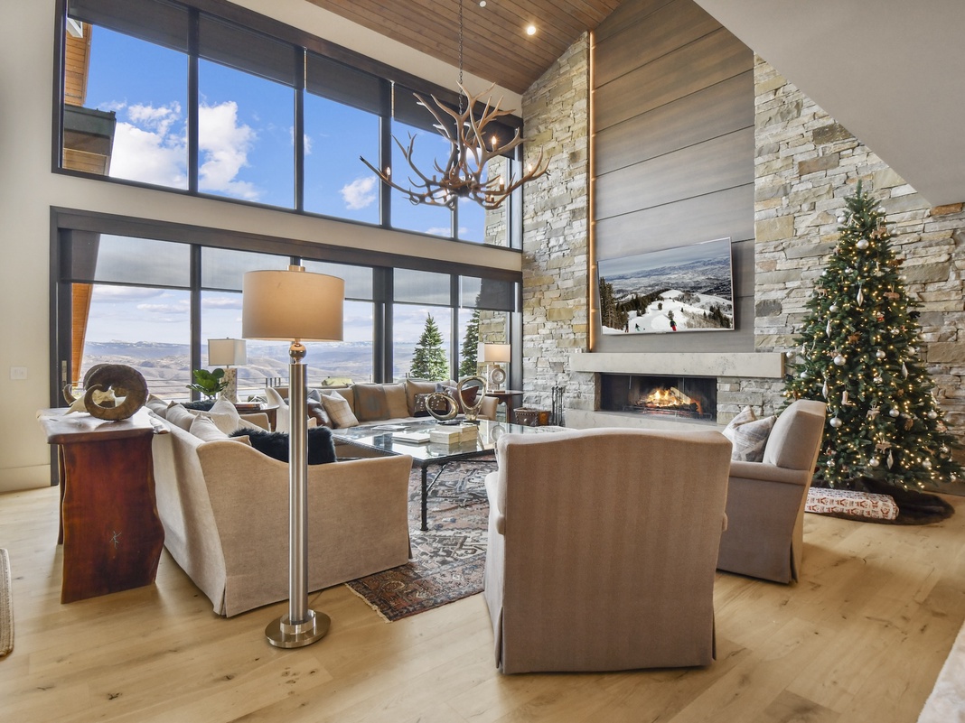 Cozy up in this stunning living room where mountain views and a crackling fireplace create your perfect winter retreat.