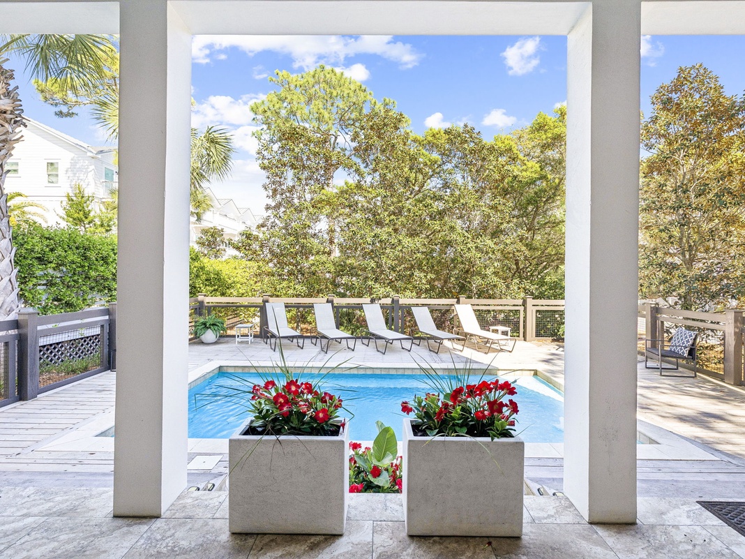 Your private pool awaits, framed by lush trees and sun loungers, where mornings feel serene and afternoons invite refreshing dips under bright blue skies.