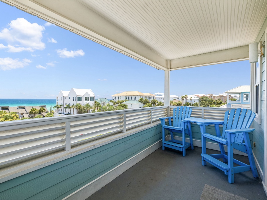 Your private balcony awaits with iconic blue Adirondack chairs, perfect for morning coffee or sunset cocktails while taking in stunning ocean views and coastal breezes.