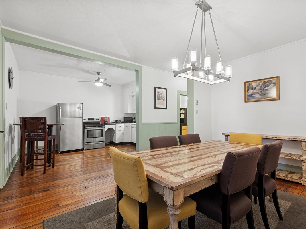 Gather around your rustic dining table where warm hardwood floors and elegant lighting create the perfect setting for memorable meals together.