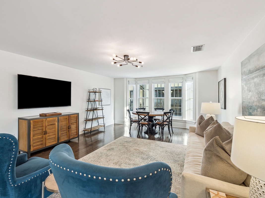 Relax in your stylish living space with plush seating, modern entertainment center, and elegant dining area perfect for memorable meals together.