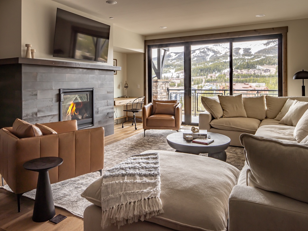 Sink into plush sofas by your crackling fireplace while soaking in stunning mountain views through floor-to-ceiling windows.