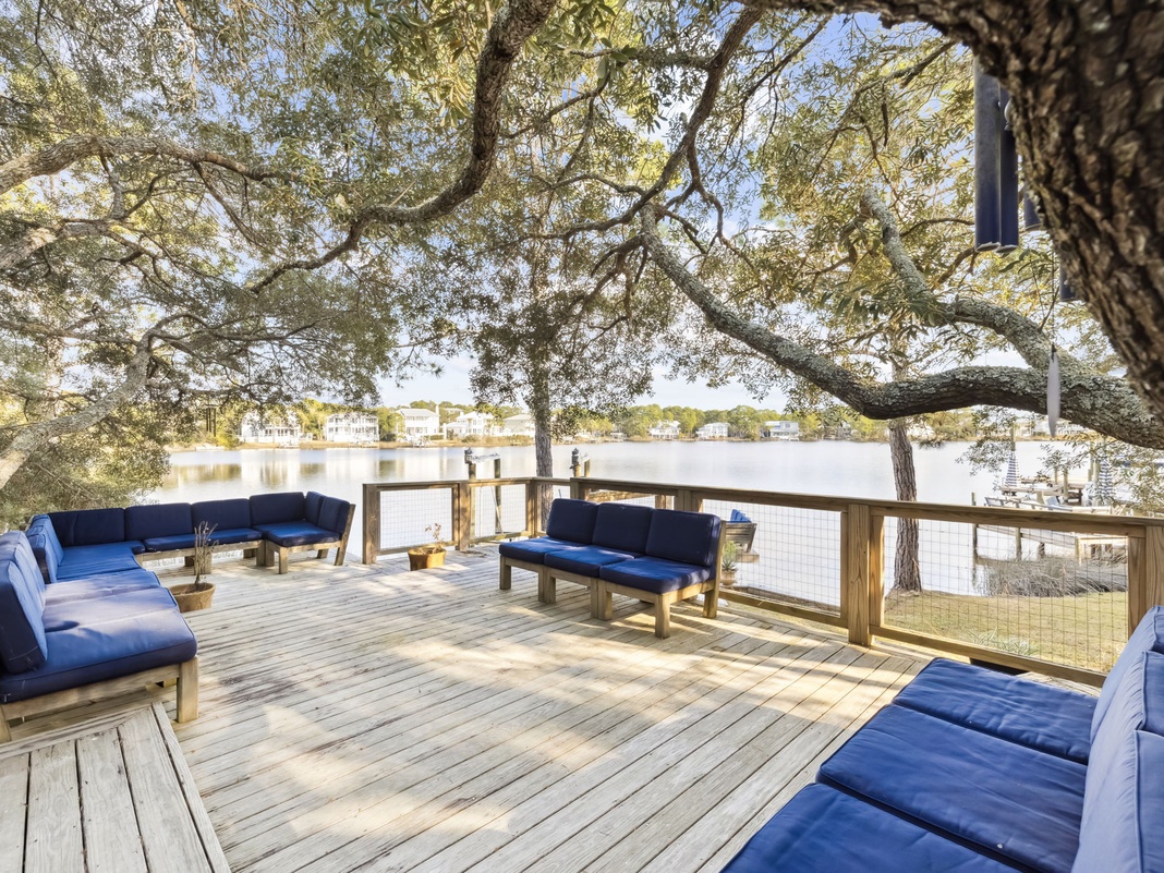 Unwind on your private waterfront deck with plush seating under ancient oaks, where peaceful lake views create the perfect backdrop for morning coffee or sunset cocktails.