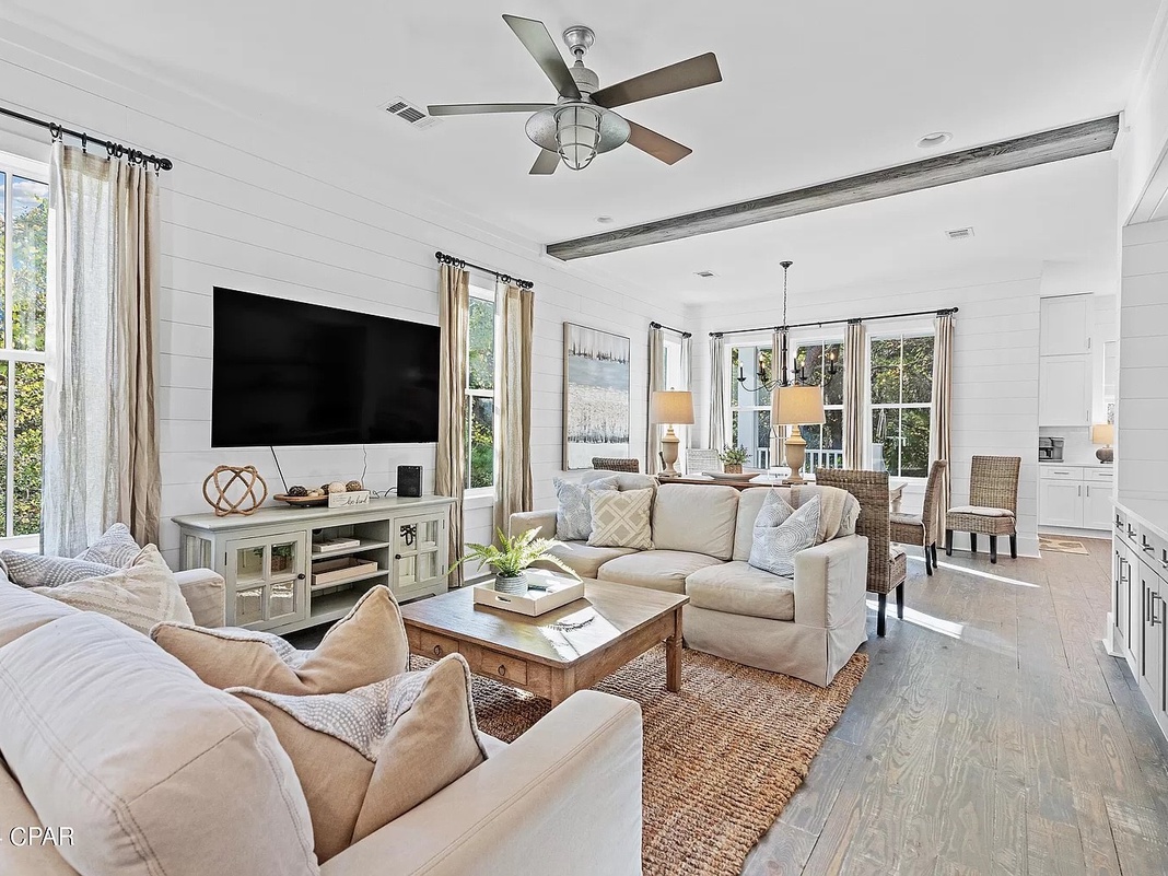 Relax into plush seating with natural light streaming through generous windows. Your coastal-chic living space feels bright and airy, perfect for unwinding after beach days.