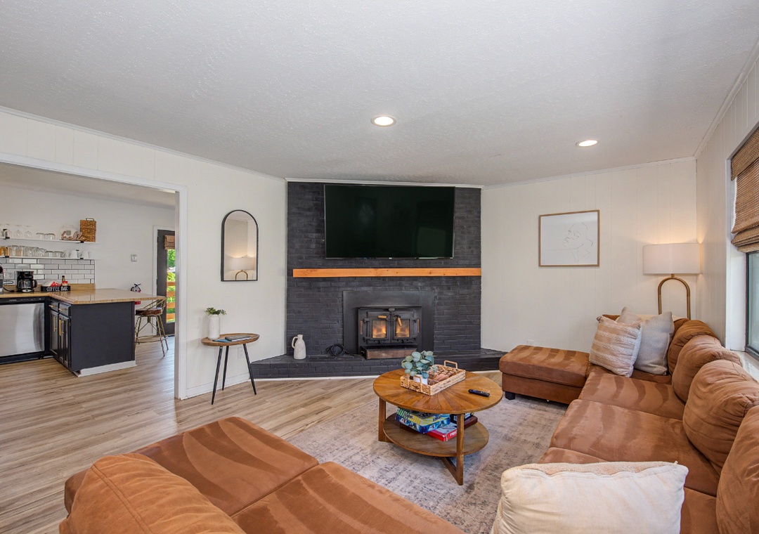 Relax in your spacious living room with cozy leather seating and a stunning stone fireplace, perfect for intimate evenings.