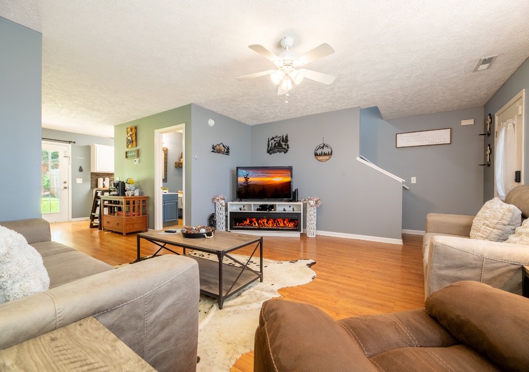 Settle into your cozy living room where warm wood floors and comfortable seating invite you to relax by the fireplace after a day of exploring.