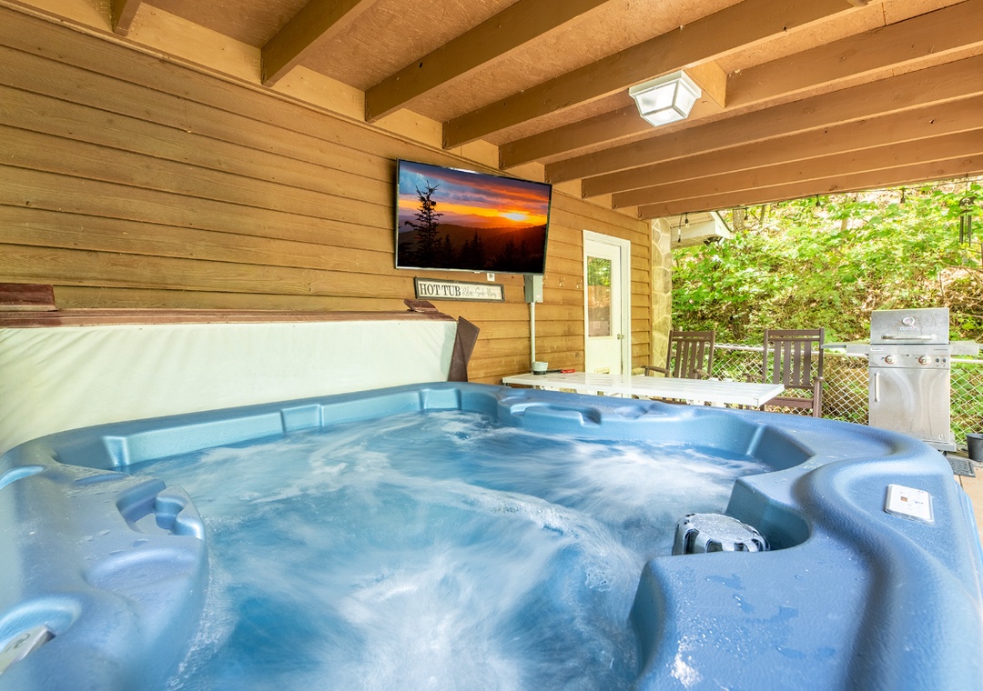 Slip into warm, bubbling water while watching your favorite shows on the outdoor TV—a perfect blend of comfort and entertainment under sheltered beams. A grill awaits for evening cookouts steps away.