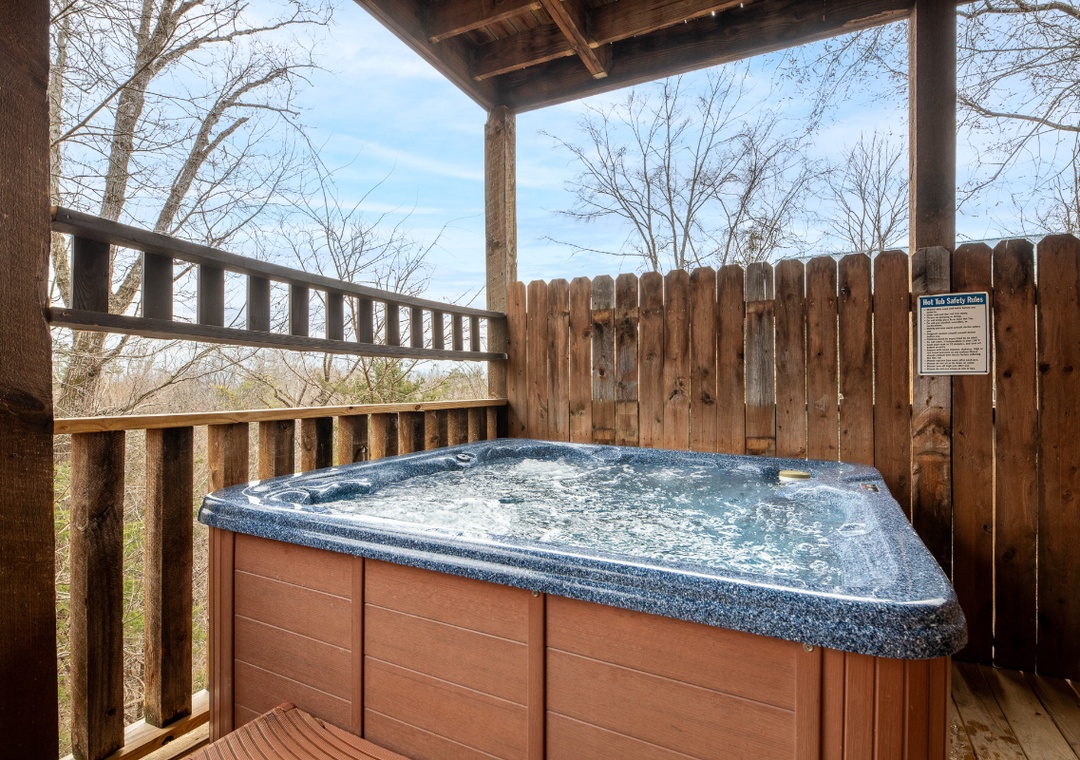 Soak in your private hot tub on the covered deck, surrounded by peaceful wooded views and complete privacy.