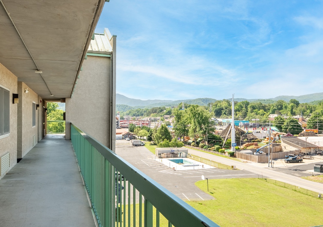 The property overlooks a small town with a long balcony providing a quiet vantage point of the surrounding neighborhood and distant peaks.